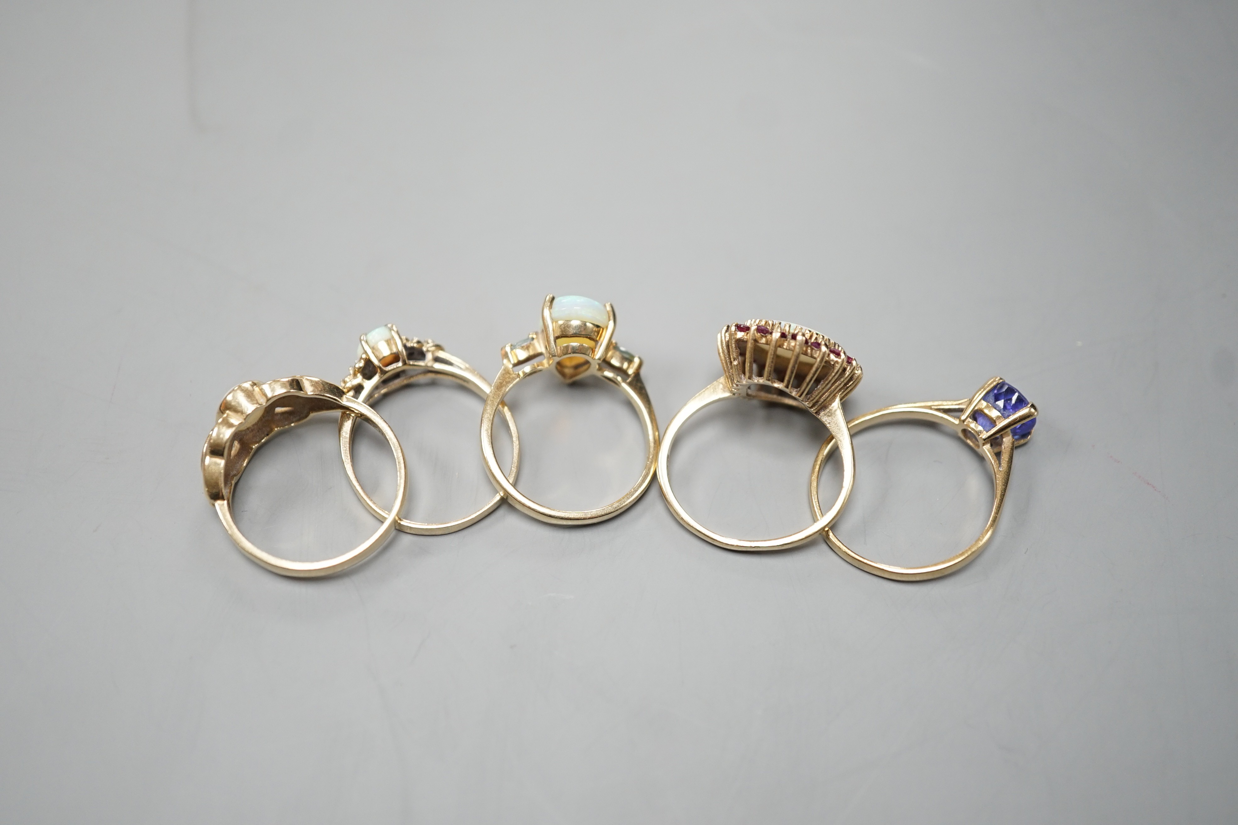 Five assorted modern 9ct gold and gem set dress rings, including white opal and garnet oval cluster, white opal and diamond chip and single stone white opal